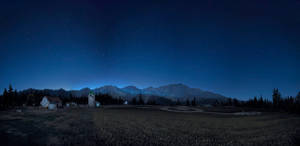 偏遠的山谷夜晚，星空下有小屋和松樹。 — 夜空 壁紙