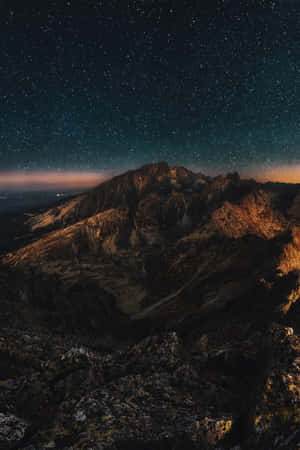 暮色中星光閃爍的山脈，山峰發光，天空昏暗 — Galaxy Note 壁紙