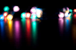 夜間在深色表面上反射的彩色模糊燈光。