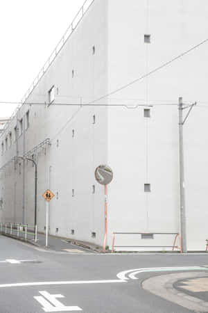 城市街角，有白色建築、交通鏡和行人過路標誌。 — 極簡美學 壁紙