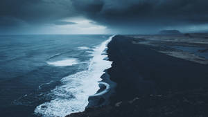 暴風雨的海浪在烏雲下衝擊黑色火山海灘。 — 沙灘 壁紙