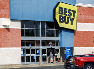 Best Buy商店入口，有顧客進入，外面停著一輛紅色貨車。