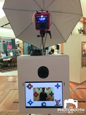 高級店內的自拍亭，屏幕顯示自拍，附傘燈。 — 3:4 壁紙