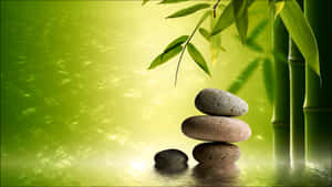 平靜水面上竹子旁堆疊的石頭，帶有柔和的綠色光芒。 — 禪 壁紙