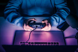 在霓虹燈下使用控制器和筆記型電腦玩遊戲的人。 — 遊戲 壁紙