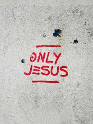 粗糙混凝土牆上的紅色噴漆文字「only jesus」
