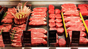 在雜貨店肉類區展示的新鮮生牛肉切塊，附有價格標籤。 — 2560x1440 壁紙