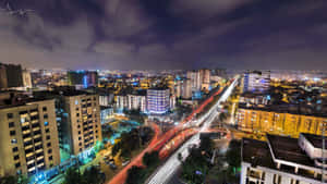 夜晚的城市，建築物閃閃發光，移動的汽車留下光跡。