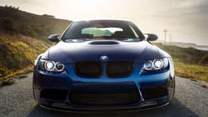 沿海公路日落時分的藍色BMW M3跑車