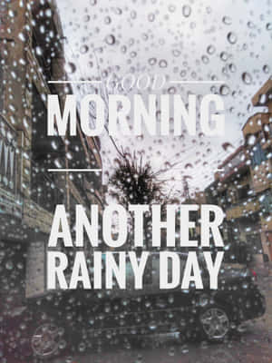 窗戶上的雨滴，俯瞰潮濕街道，有停泊的汽車和建築物。