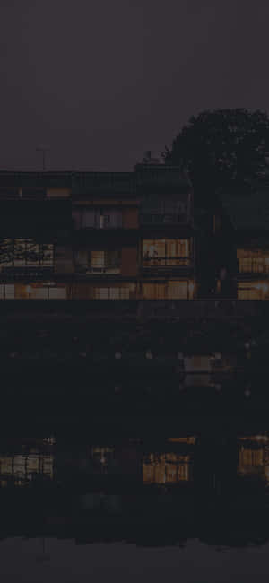 夜晚的傳統房屋，溫暖的燈光倒映在水中