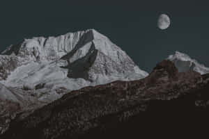 夜晚新月下的雪山山峰。 — MacBook Pro 14 壁紙