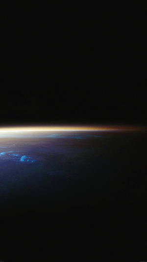 從太空看地球彎曲的地平線閃耀著日落色彩。