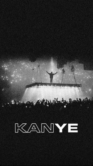 Kanye 在舞台上，在明亮的燈光下，高舉雙臂，面向歡呼的人群。