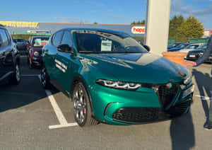 綠色Alfa Romeo Tonale SUV停泊在汽車經銷商場地，有人做手勢。