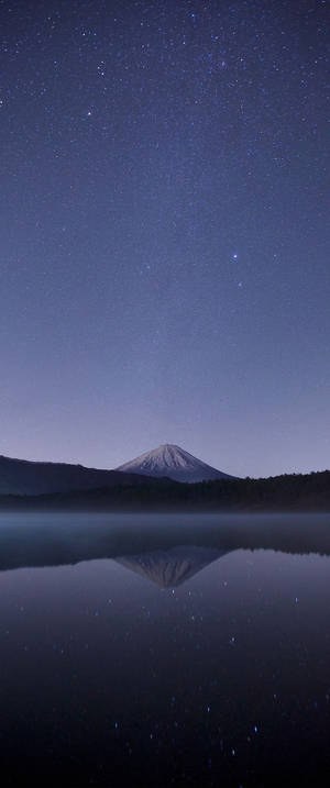 富士山在星空下倒映在湖面上。