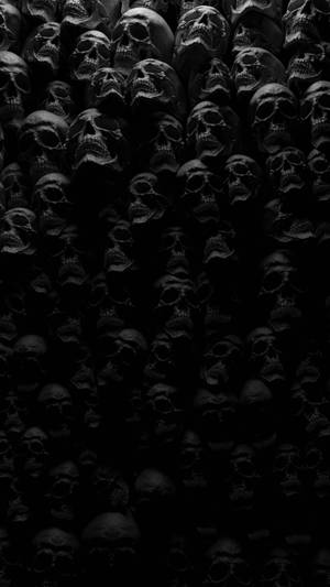 黑色同灰色色調中密集排列嘅人類頭骨Wallpaper。