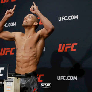 剃光頭的UFC拳手在稱重時高舉食指慶祝勝利。