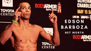 赤裸上身的拳手 Edson Barboza 在記者會上指向上方。