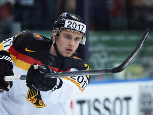 德國冰球運動員在比賽中穿著隊服和帶有2017的頭盔進行比賽。