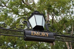 黑色鍛鐵標牌，上面寫著 Emory 並帶有燈籠，周圍環繞著綠樹。