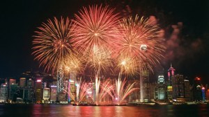 煙火在夜間水面上反射的明亮城市天際線上綻放。 — 中國新年 壁紙