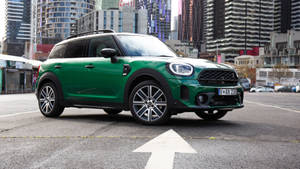 綠色MINI Countryman SUV停泊在高樓附近的城市停車場。 — 城市 壁紙