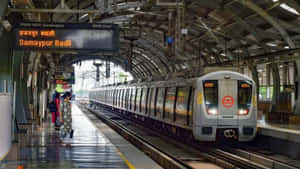 Samaypur Badli站的銀色地鐵列車，乘客在月台上等候。