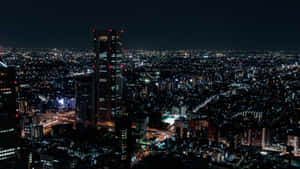 密集城市區域的夜間鳥瞰圖，建築物和街道閃閃發光。 — 夜晚 GIF 壁紙