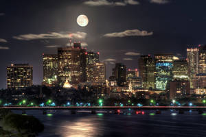 夜間城市天際線，滿月與河流倒影