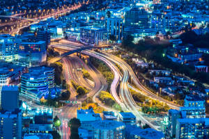 夜間城市鳥瞰圖，有發光的高速公路和燈火通明的建築物。