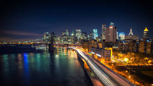 夜間城市景觀，橋樑上車輛的光跡和燈火通明的摩天大樓。 — 夜景城市 壁紙