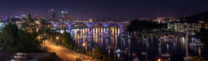 夜景城市景觀，橋樑和船隻在水上發光。 — 夜晚 GIF 壁紙