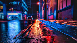 雨濕嘅城市街道夜晚閃爍住霓虹倒影。 — 夜晚 GIF 壁紙