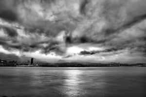 水面上的城市天際線，戲劇性的暴風雲下黑白影像。 — 唯美雲朵動態 壁紙
