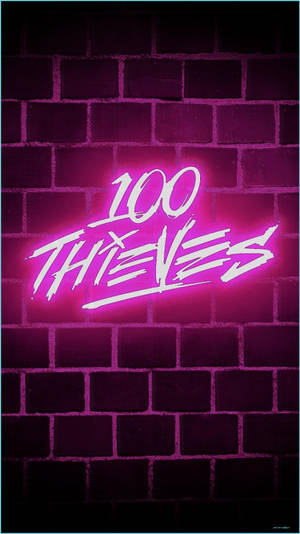 喺黑暗嘅磚牆上，一個寫住 100 THIEVES 嘅粉紅色霓虹燈牌。