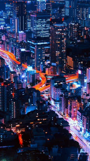 充滿活力的夜晚城市，有發光的建築物和流動的車流燈光。