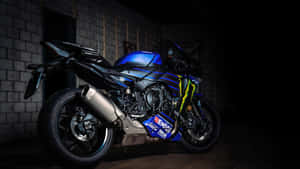 在昏暗車庫中的藍黑Yamaha R1電單車，帶有Monster Energy貼花。