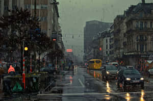 黃昏時分的城市街道，下雨，濕漉漉的路面反射燈光。