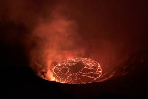 夜間火山口內發光的熔岩湖，煙霧升騰 — 自然 壁紙