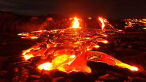 熔岩流和噴發在夜間照亮了黑暗的火山景觀。