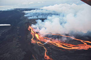 火山爆發時發光的熔岩流和煙霧的鳥瞰圖。