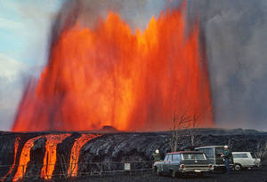 火山爆發，明亮的橙色熔岩，人們站在汽車附近。