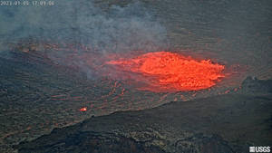 火山爆發，明亮的紅色熔岩流過黑色的火山岩。