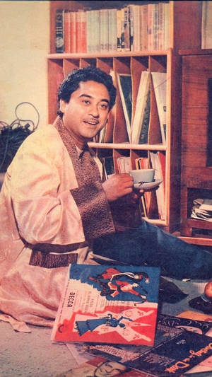 穿長袍的男人坐在地板上，周圍有唱片和書籍