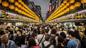 擁擠的夜市街道，有發光的燈籠和食物攤位。