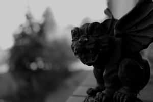 一個展開翅膀的石像鬼石雕，以黑白配色棲息在壁架上。