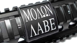 步槍導軌的特寫，上面有一塊寫著 Molon Labe 的牌子。