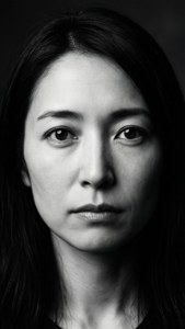 一位黑髮嚴肅女性的特寫黑白肖像。