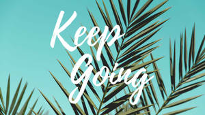 勵志名言 Keep Going 在棕櫚葉上，以藍綠色天空為背景